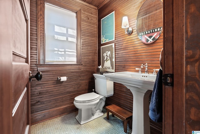4603 Clairmont Ave, Birmingham, AL 35222 - half bath featuring toilet, a sink, tile patterned floors, and wood walls