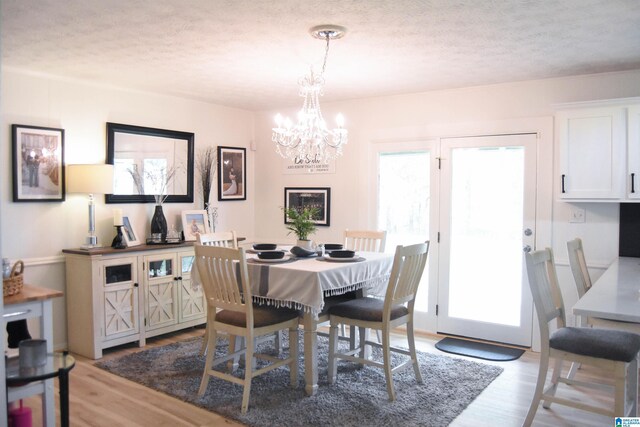 dining room with plenty of natural light, a notable chandelier, and light wood-style floors