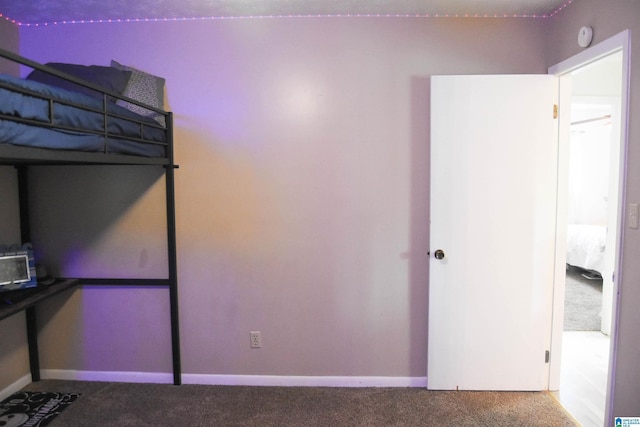 unfurnished bedroom featuring baseboards and carpet