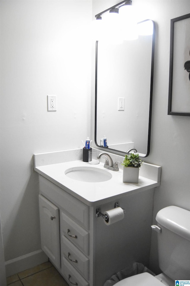 half bath with tile patterned flooring, vanity, and toilet