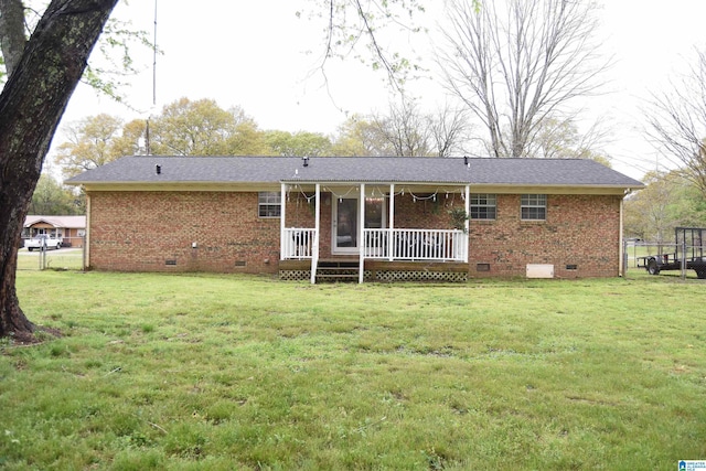 rear view of house with covered porch, brick siding, crawl space, and a lawn