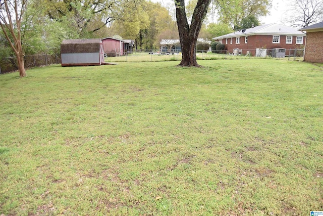 view of yard featuring a fenced backyard, an outbuilding, and a storage shed