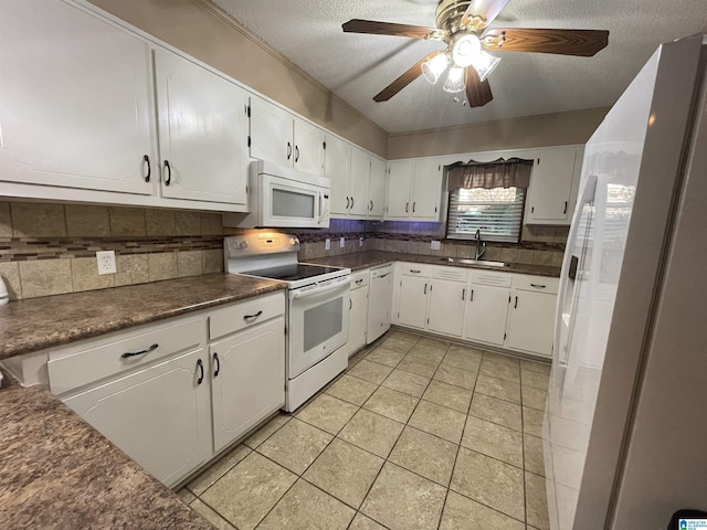 kitchen featuring a sink, backsplash, dark countertops, and white appliances