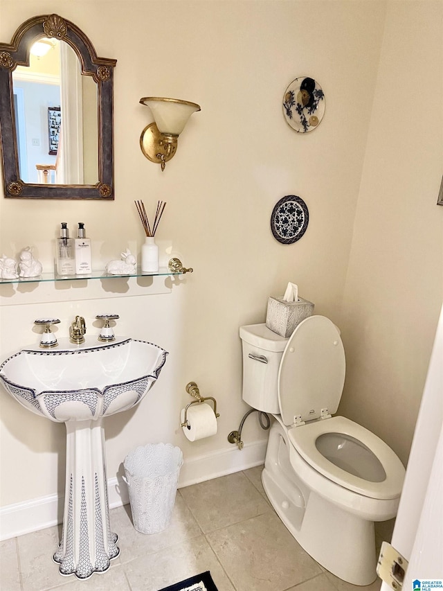 bathroom featuring baseboards, toilet, and tile patterned flooring