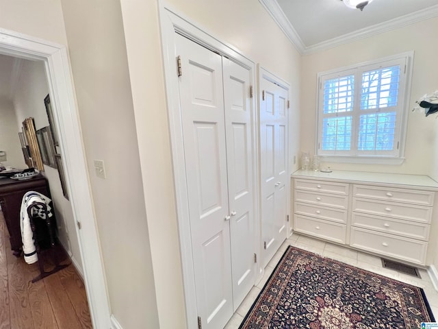 hall featuring visible vents and ornamental molding