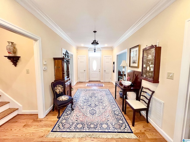 entrance foyer featuring stairs, ornamental molding, baseboards, light wood finished floors, and visible vents