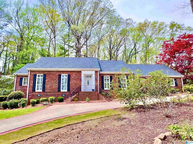 ranch-style home with driveway, brick siding, and crawl space