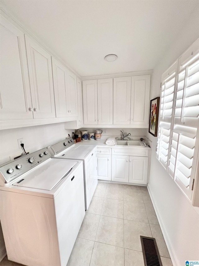 laundry room with light tile patterned flooring, visible vents, independent washer and dryer, a sink, and cabinet space