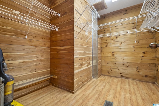 walk in closet with light wood finished floors and visible vents