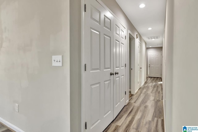 corridor featuring baseboards, light wood-style flooring, visible vents, and recessed lighting