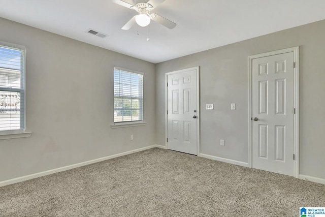 unfurnished bedroom featuring baseboards, visible vents, carpet floors, and a ceiling fan