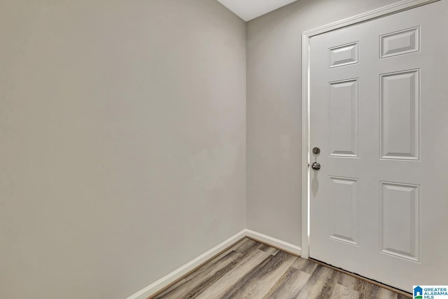 doorway to outside featuring baseboards and light wood-style floors