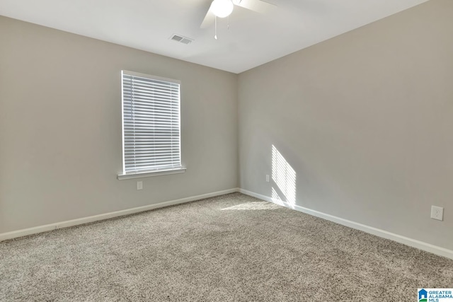 carpeted spare room featuring baseboards, visible vents, and a ceiling fan