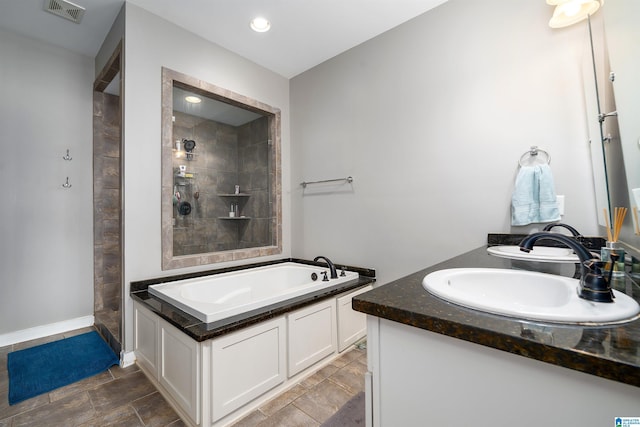 full bathroom with a garden tub, visible vents, a sink, and a tile shower