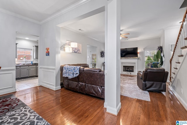 471 River Oaks Ln, Helena, AL 35080 - living area with light wood finished floors, stairway, ornamental molding, a ceiling fan, and a fireplace