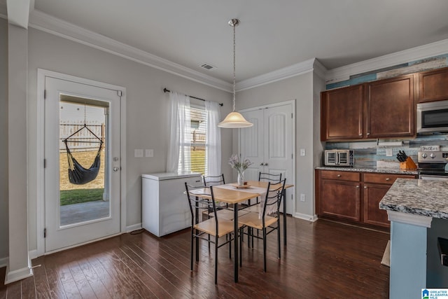 dining room with dark wood finished floors, baseboards, ornamental molding, and visible vents
