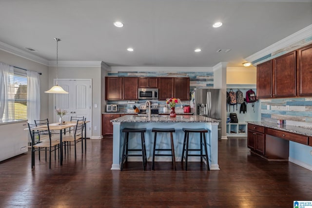 kitchen with a kitchen bar, crown molding, decorative backsplash, and stainless steel appliances