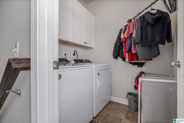 clothes washing area featuring washer and dryer, baseboards, and cabinet space