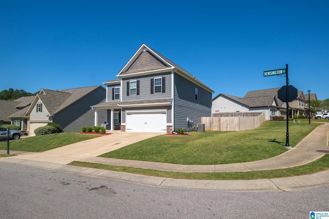 craftsman inspired home with a front yard, an attached garage, fence, and concrete driveway
