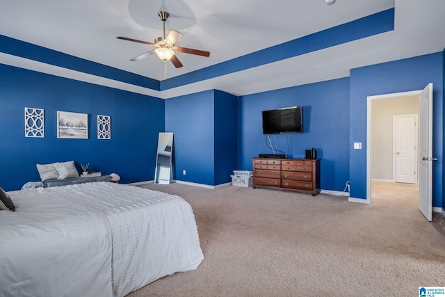 bedroom with baseboards, a raised ceiling, carpet, and a ceiling fan