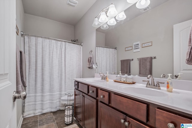 full bath featuring a sink, visible vents, and double vanity