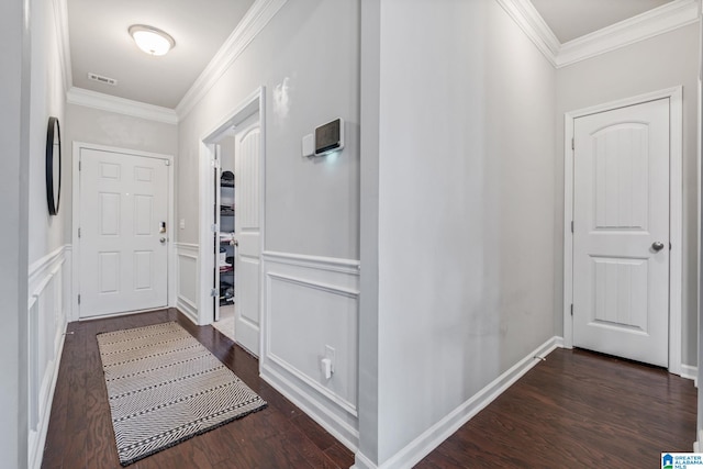 hall with visible vents, crown molding, a wainscoted wall, and dark wood-style floors