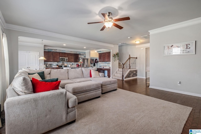 living area featuring visible vents, dark wood-style flooring, ornamental molding, a ceiling fan, and stairs