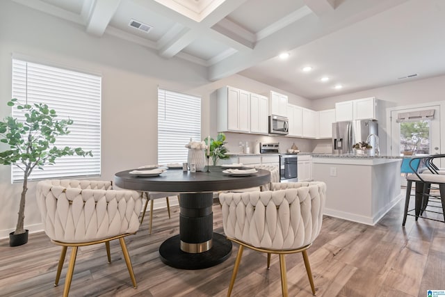 dining room with beamed ceiling, visible vents, and light wood-style floors
