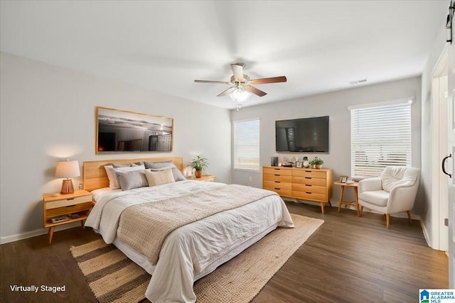 bedroom featuring a ceiling fan, baseboards, dark wood finished floors, and visible vents