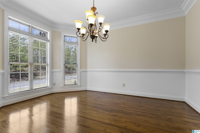 empty room featuring crown molding, dark wood-style flooring, baseboards, a chandelier, and visible vents