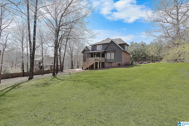exterior space with a lawn, stairs, and fence