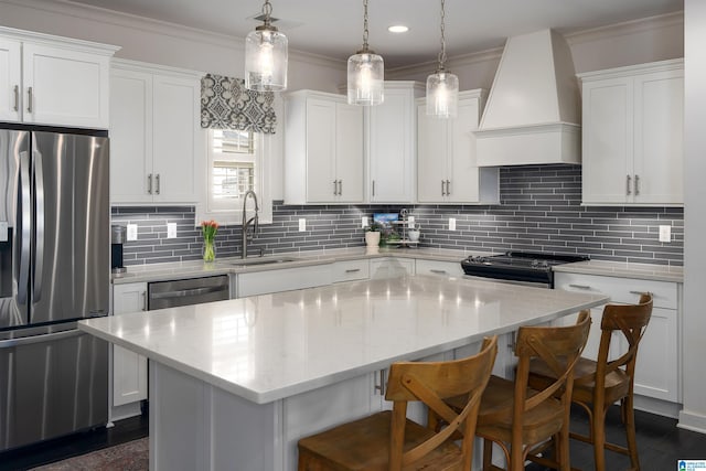 4460 Tuckahoe Ln, Hoover, AL 35226 - kitchen with a center island, a sink, appliances with stainless steel finishes, premium range hood, and crown molding