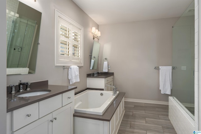 4460 Tuckahoe Ln, Hoover, AL 35226 - bathroom with two vanities, baseboards, a stall shower, a bath, and a sink