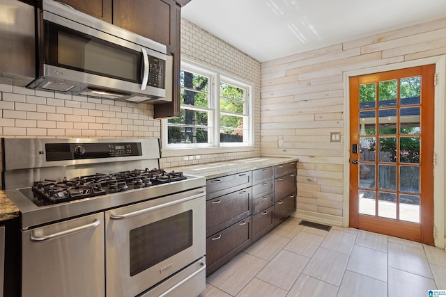 5605 7th Ave S, Birmingham, AL 35212 - kitchen with dark brown cabinets, visible vents, decorative backsplash, light stone counters, and appliances with stainless steel finishes