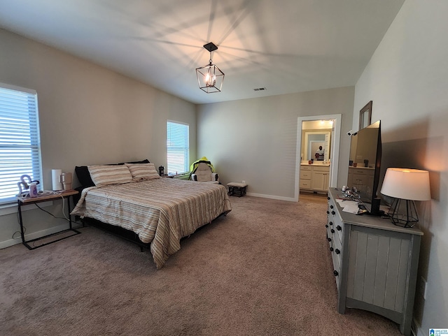 bedroom with light carpet, baseboards, and connected bathroom