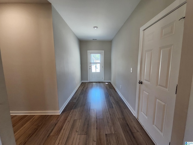 doorway to outside with dark wood-type flooring and baseboards