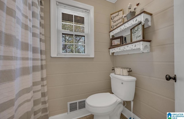 bathroom featuring a shower with curtain, toilet, and visible vents