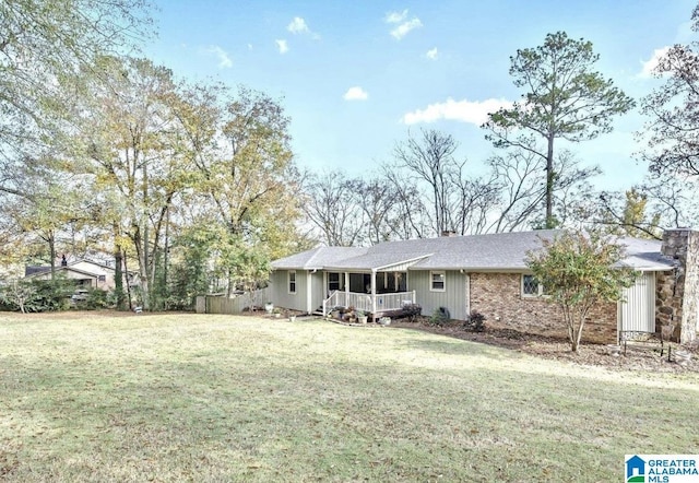 view of front of home featuring a front lawn, a chimney, and covered porch