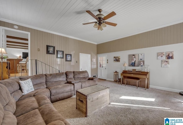 living area featuring baseboards, light colored carpet, ornamental molding, and a ceiling fan