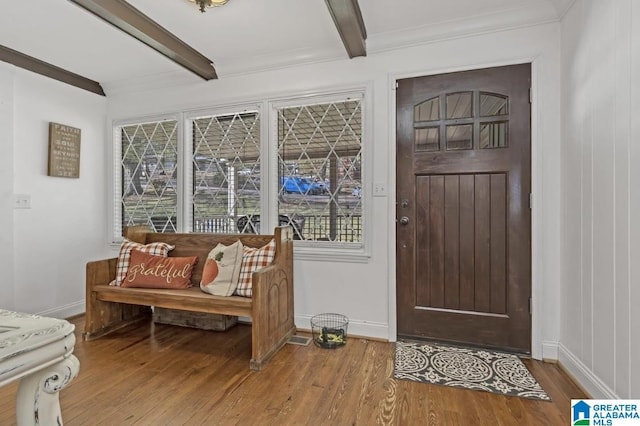 entryway featuring baseboards, crown molding, wood finished floors, and beam ceiling