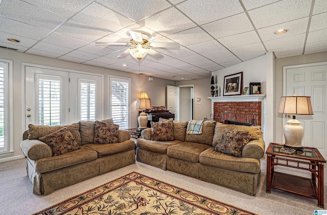 2240 Hillview Rd, Birmingham, AL 35022 - living area with visible vents, a brick fireplace, ceiling fan, a paneled ceiling, and carpet flooring