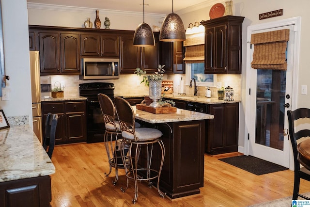 100 Edgewood Cir, Oneonta, AL 35121 - kitchen featuring dark brown cabinetry, a sink, appliances with stainless steel finishes, light wood-style flooring, and ornamental molding