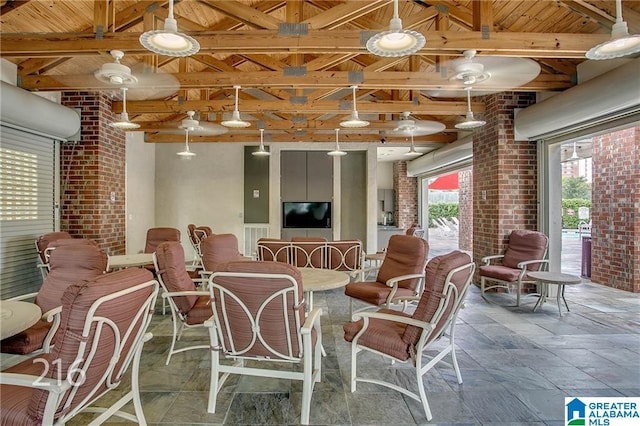 600 13th St E Unit 914, Tuscaloosa, AL 35401 - dining area with stone tile floors, brick wall, wood ceiling with exposed beams, and a ceiling fan