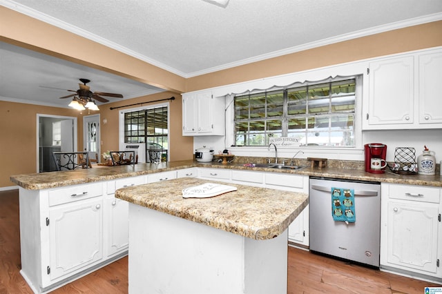 kitchen featuring stainless steel dishwasher, a sink, light wood finished floors, white cabinets, and a peninsula