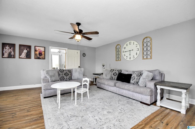 living area with wood finished floors, baseboards, and ceiling fan