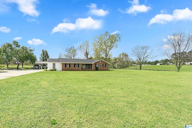 single story home with a front lawn, concrete driveway, and a carport