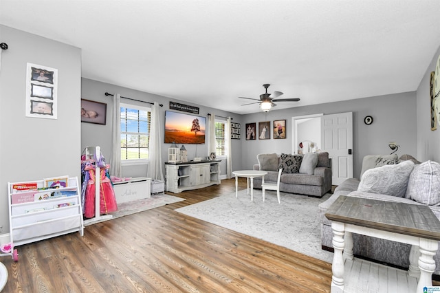 living area featuring a ceiling fan and wood finished floors