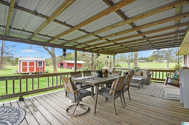 wooden deck featuring a storage unit, a lawn, outdoor dining area, and an outdoor structure