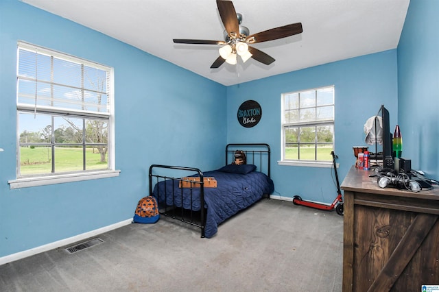 carpeted bedroom featuring baseboards, visible vents, and a ceiling fan