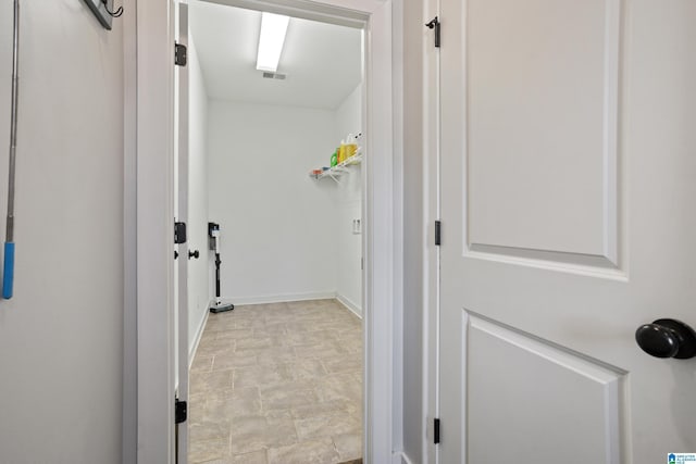 corridor featuring baseboards and stone finish flooring